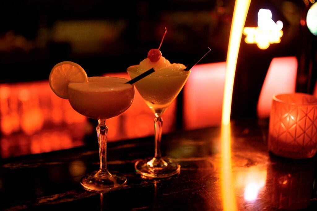 Two cocktails glowing on the bar